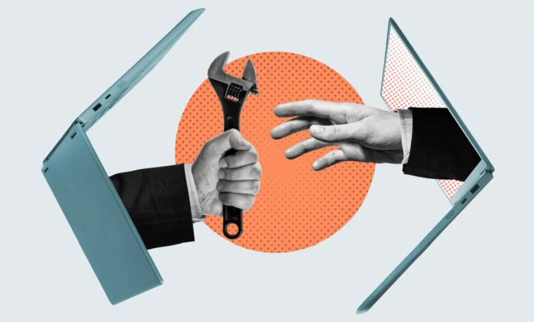 Hands exchanging a wrench through laptops, symbolizing technical support or IT solutions.