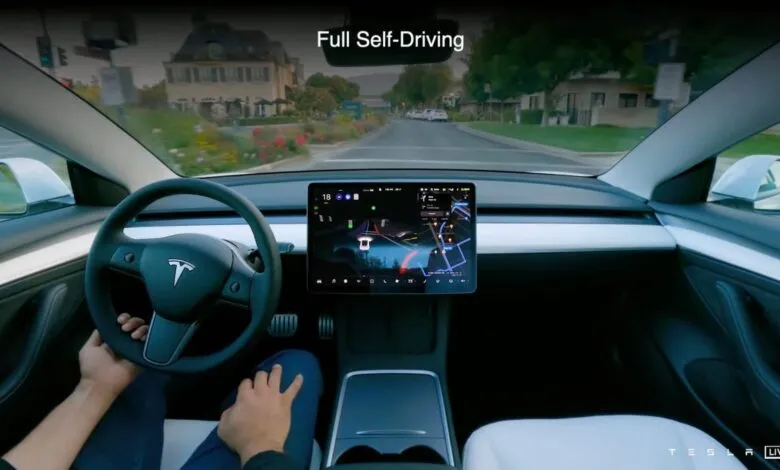 Interior view of Tesla car using Full Self-Driving mode on city street.