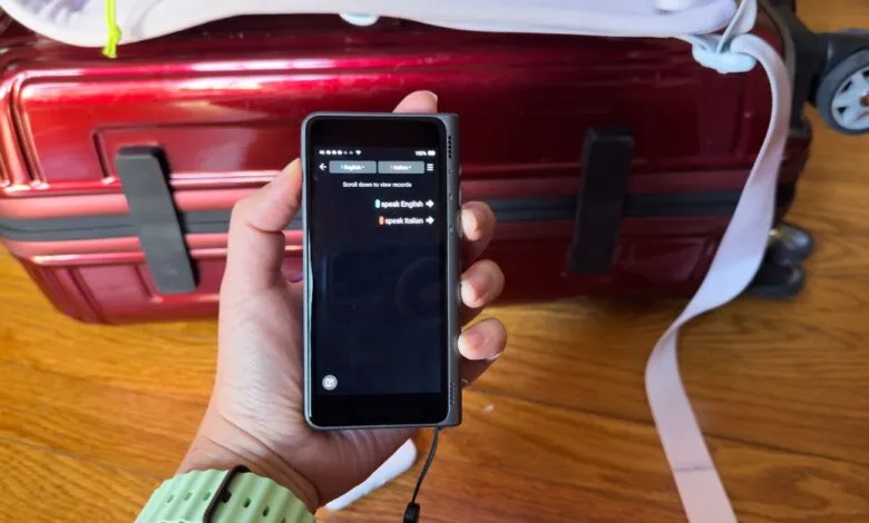 Person holding a portable translator device with English to Italian translation options