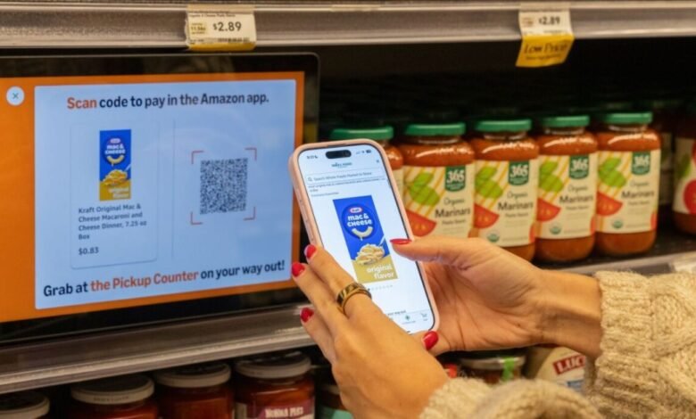 Person using a smartphone to scan a QR code on a grocery store display for a Kraft Mac & Cheese purchase.