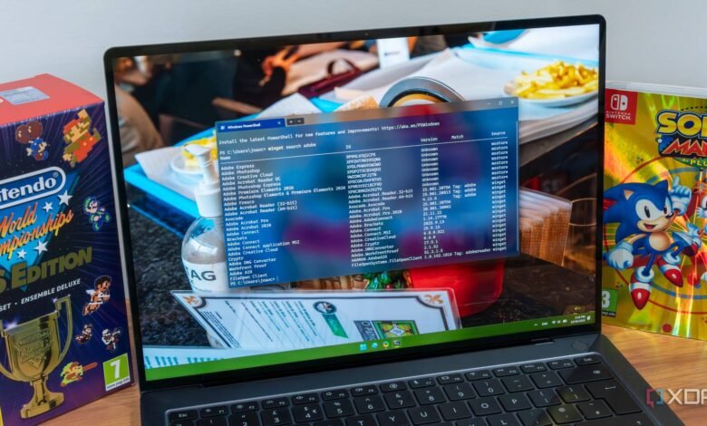 Laptop displaying Windows PowerShell with a list of Adobe software and Winget search results.
