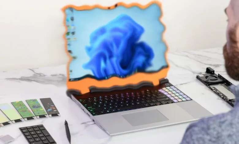 Laptop screen displaying Windows 11 logo with a wavy orange frame, next to a keyboard and accessories.