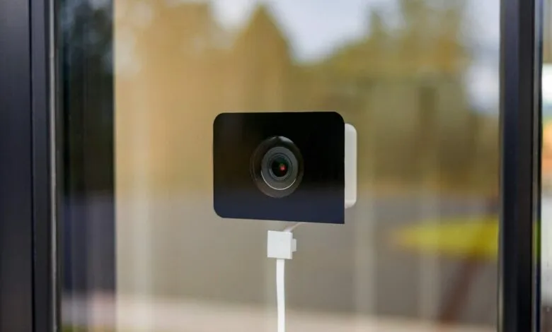 Wyze window camera mounted on glass, providing home security.