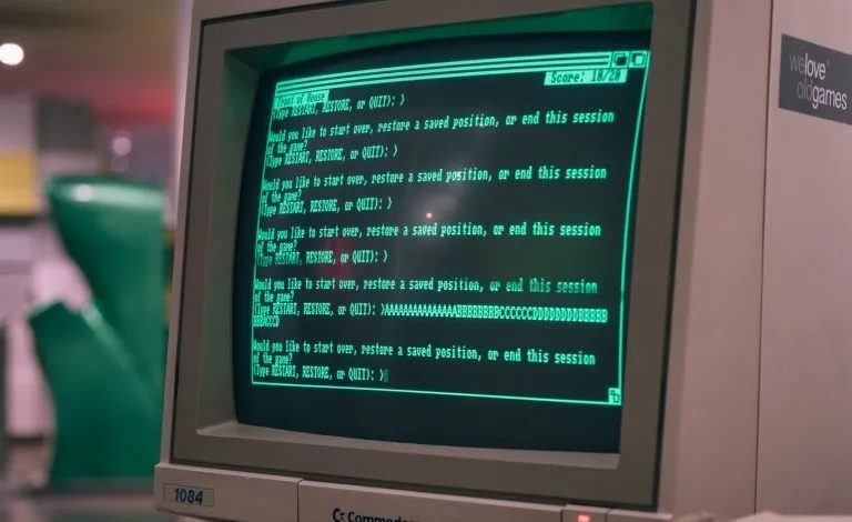 Close-up of a vintage Commodore 1084 monitor displaying a green text-based game prompt.