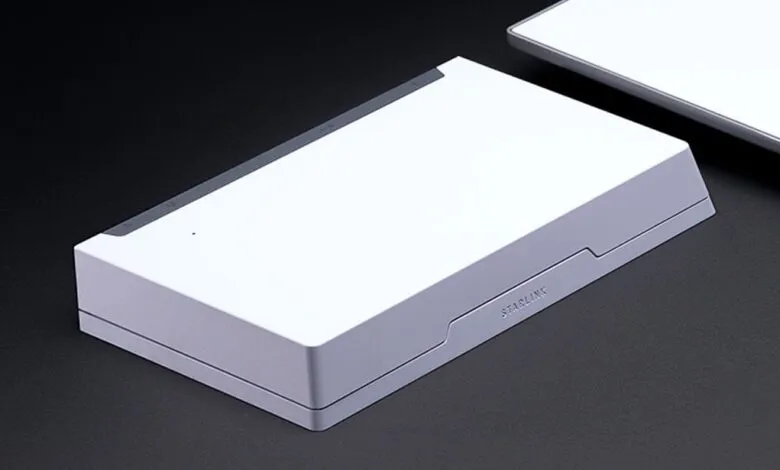Starlink router on a dark surface, showcasing its minimalist design.