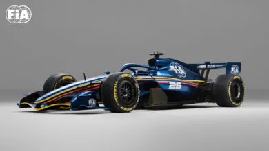 Formula race car with a sleek, dark blue and yellow design, number 26.