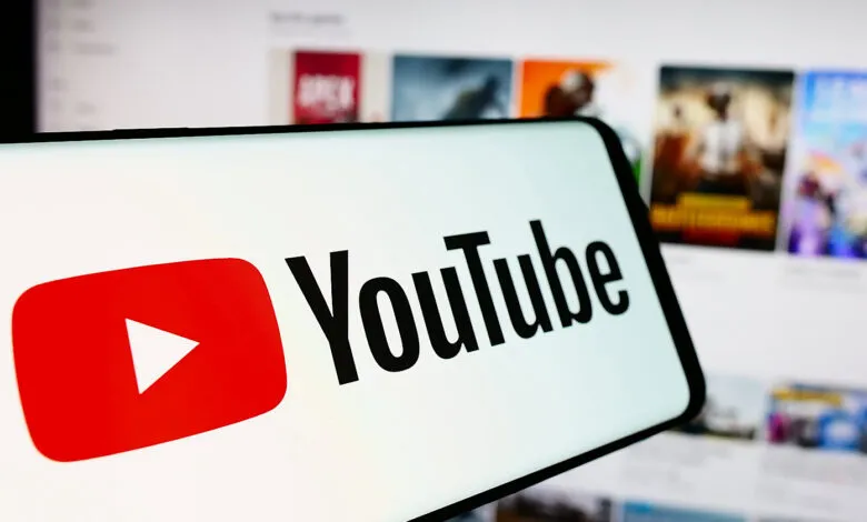 YouTube logo displayed on a smartphone screen with website in background.