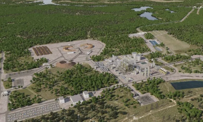 Aerial view of a large industrial complex surrounded by forest and wetlands.