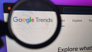 Google Trends website displayed on a computer screen, viewed through a magnifying glass.