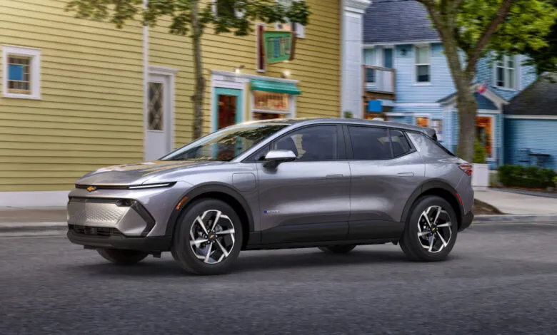 Gray 2024 Chevrolet Equinox EV 1LT driving on a city street.