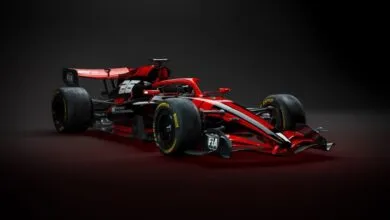 Sleek red and black Formula 1 race car against a dark backdrop.