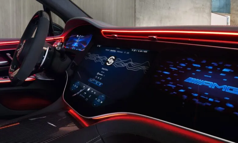 Interior view of a Mercedes-AMG electric car with digital displays and red ambient lighting.
