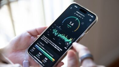 Person holds phone displaying stress monitor app with graph and data.