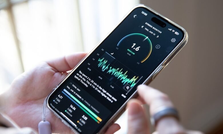 Person holds phone displaying stress monitor app with graph and data.