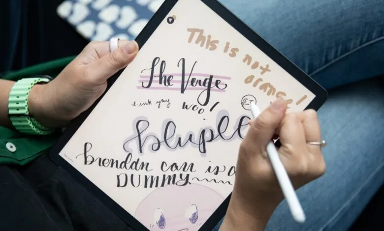 Person writing on a Kindle Scribe with a stylus, showcasing digital handwriting.