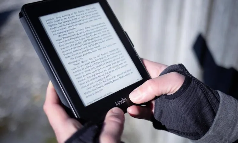 Hands holding a Kindle e-reader displaying German text.