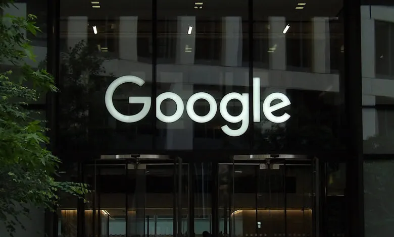 Google logo above revolving doors of a modern office building.