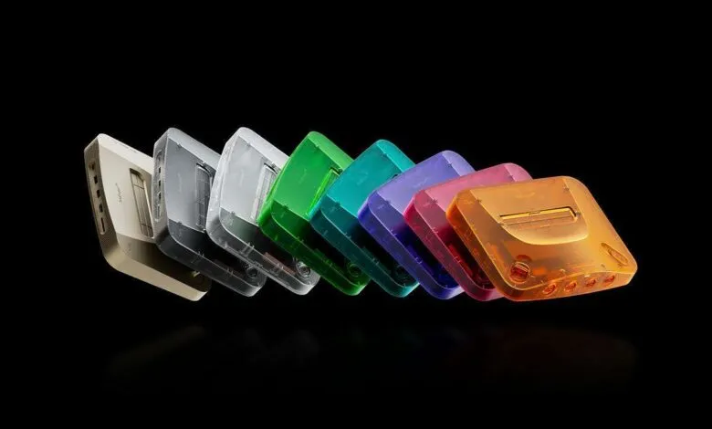 Row of colorful translucent Nintendo 64 consoles against a black background.