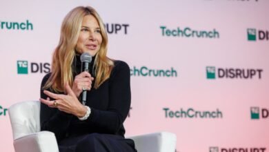 Joanna Coles speaks at TechCrunch Disrupt, holding a microphone.