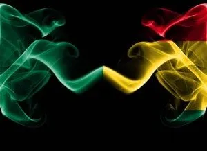 Abstract smoke art featuring green, yellow, and red colors on a black background.