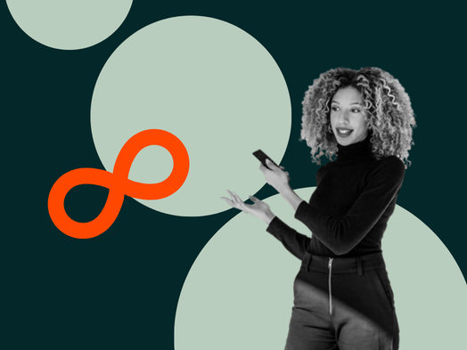 Woman with curly hair holding phone, gesturing against abstract background.