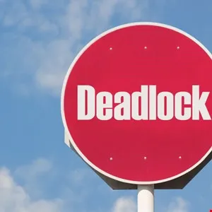 Red circular sign with the word 'Deadlock' in white letters against a blue sky.