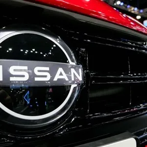 Close-up of a Nissan car's front grille and logo, showcasing its design.