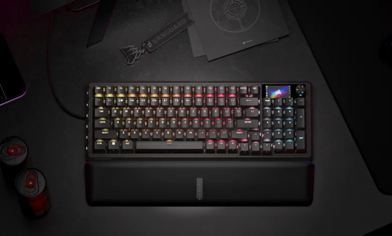 Corsair keyboard with RGB lighting on a dark desk with accessories.