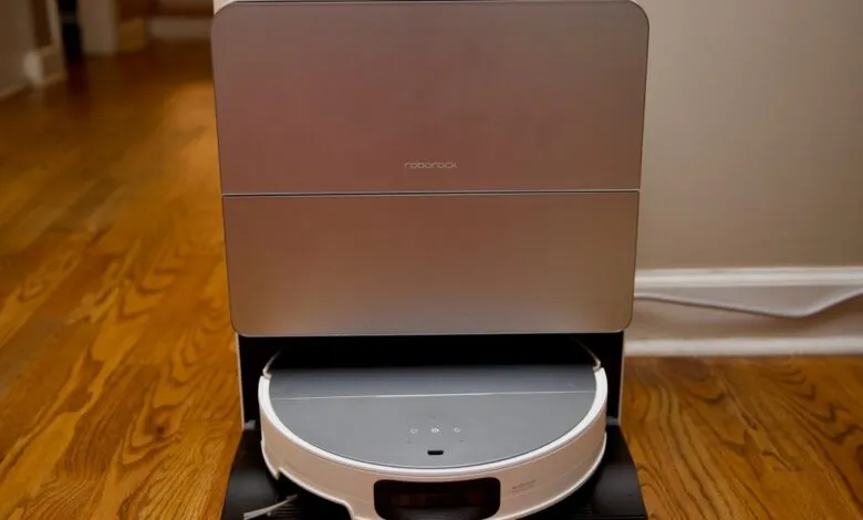 Roborock robot vacuum cleaner docked in its charging and self-emptying station.