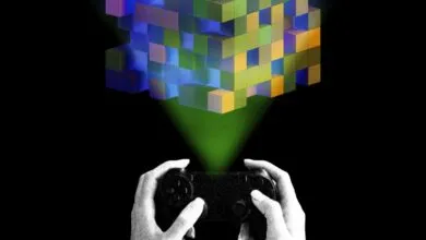 Hands hold a controller under a floating cube of colorful blocks.
