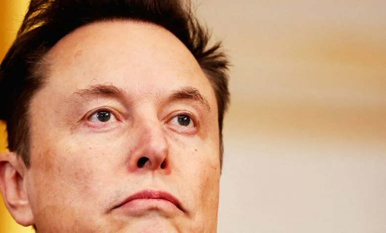 Close-up of Elon Musk looking upwards with a thoughtful expression.