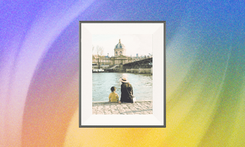 Framed print of mother and child sitting by Seine River in Paris.