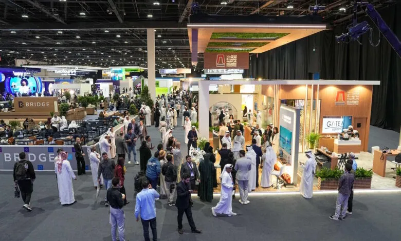 Large crowd at a busy conference or trade show with booths and attendees.