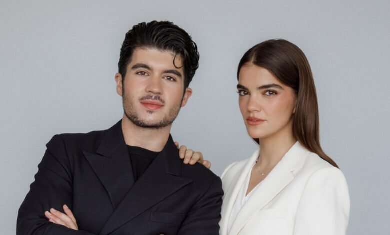 Headshot of a man and woman in business attire against a gray backdrop.
