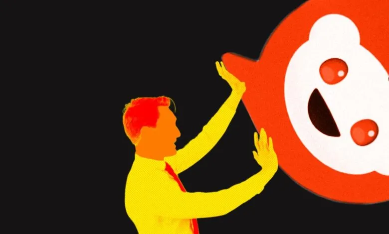 Man pushes away large Reddit logo, symbolizing platform changes.
