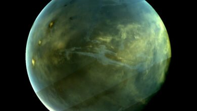 Image of Titan, Saturn's largest moon, showing its hazy atmosphere and surface features.