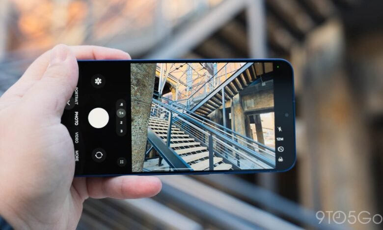 Hand holding smartphone taking photo of stairs with metal railings.