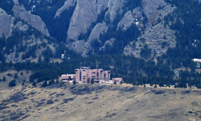 NCAR building nestled in Boulder, Colorado landscape with Flatirons.