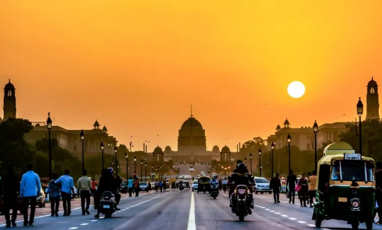 Sunset view of Rajpath, New Delhi, with people and vehicles.