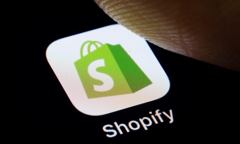 Shopify app icon on a smartphone screen, finger touching the screen.