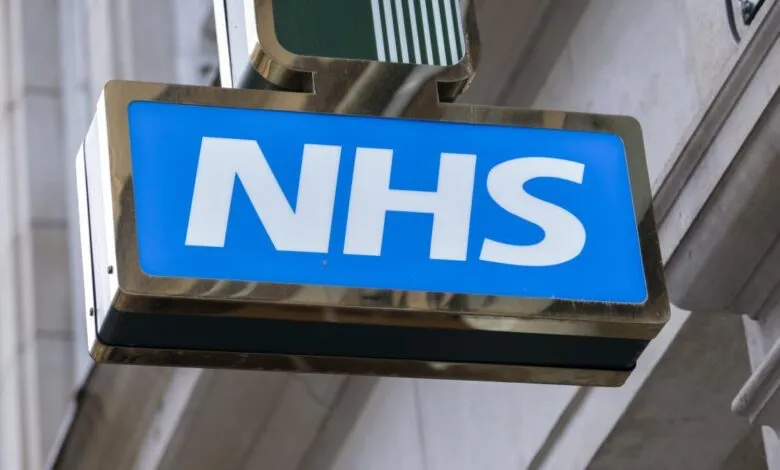 NHS sign with blue background and white letters on a building.
