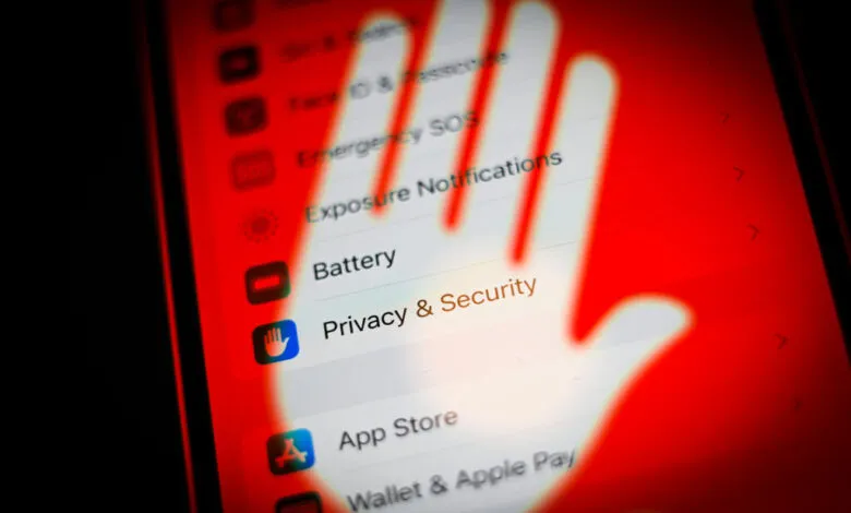 iPhone screen showing Privacy & Security settings with a red hand overlay.