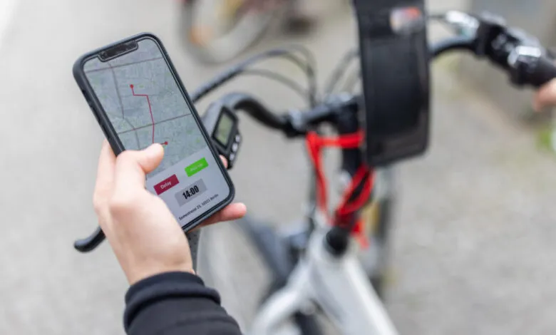 Delivery person on bike uses smartphone for GPS navigation.