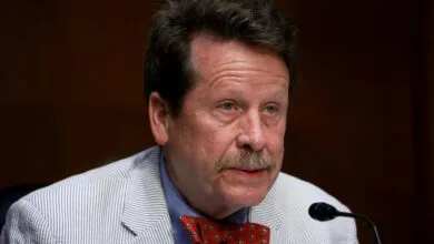 Robert Califf testifies wearing a striped jacket and bow tie.