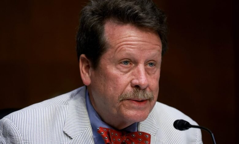 Robert Califf testifies wearing a striped jacket and bow tie.