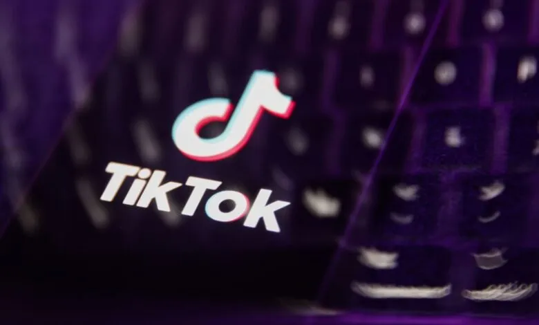 Close-up of the TikTok logo on a dark, reflective surface.