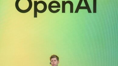 Sam Altman, CEO of OpenAI, speaking in front of the OpenAI logo.