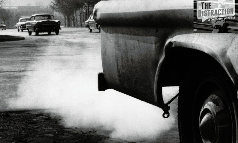Vintage cars emit exhaust fumes, contributing to air pollution in a city.