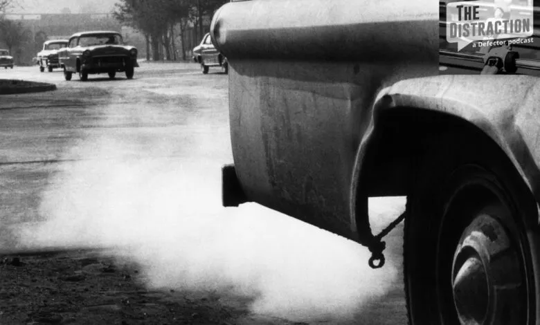 Vintage cars emit exhaust fumes, contributing to air pollution in a city.