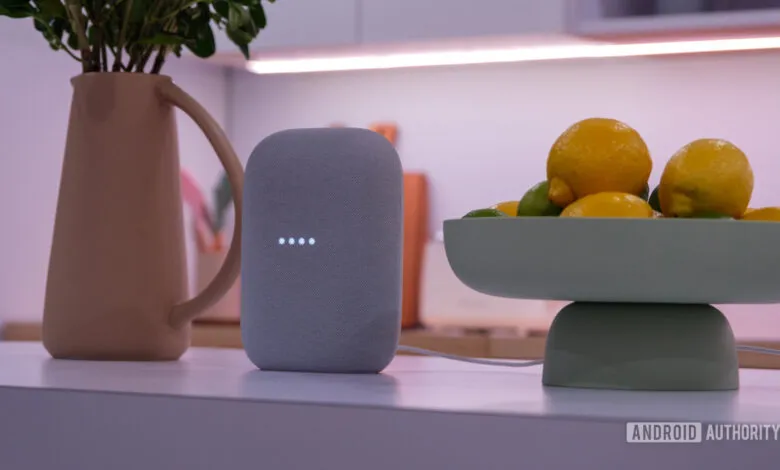 Google Nest Audio speaker with glowing lights on a kitchen counter.
